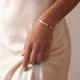 Modelka z personalizowaną złotą bransoletką bangle z miejscem na grawer tekstu lub współrzędnych