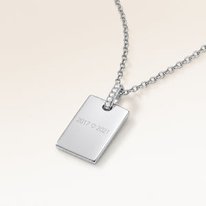 Personalised square silver necklace with white zirconia seen from the side, with years and a heart engraved on the front