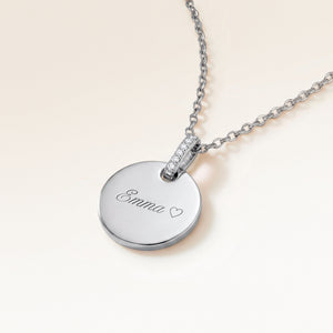 Round silver necklace with zirconia seen from the side with an engraved name and heart