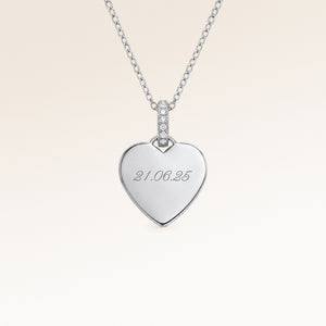 Close-up of minimalist heart-shaped heart pendant in silver with white zircons and space for personalized engraving on the front and back