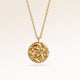 Close-up of minimalist round pendant in gold with softly melted finish and space for engraving on back