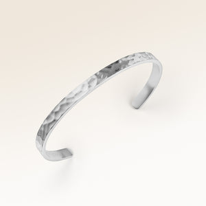 Zbliżenie minimalistycznej bransoletki bangle w srebrze z falowaną powierzchnią i miejscem na spersonalizowany grawer