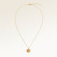 Personalized round gold necklace with rippled wave surface and space for engraving of text, coordinates or handwriting on the back