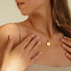 Personalized round gold necklace with white zircons and space for engraving of text, coordinates or handwriting on the front and back