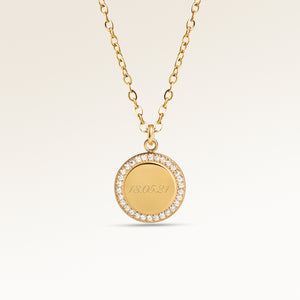 Personalized round gold necklace with white zircons along the edge and space for engraving of 8 characters on one line on the front