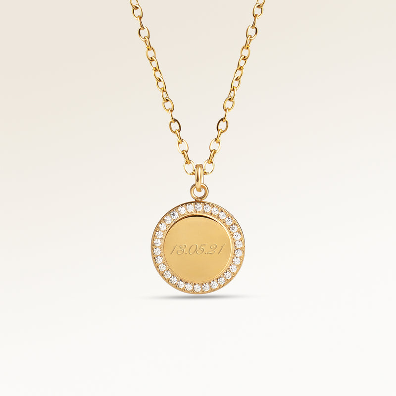 Personalized round gold necklace with white zircons along the edge and space for engraving of 8 characters on one line on the front