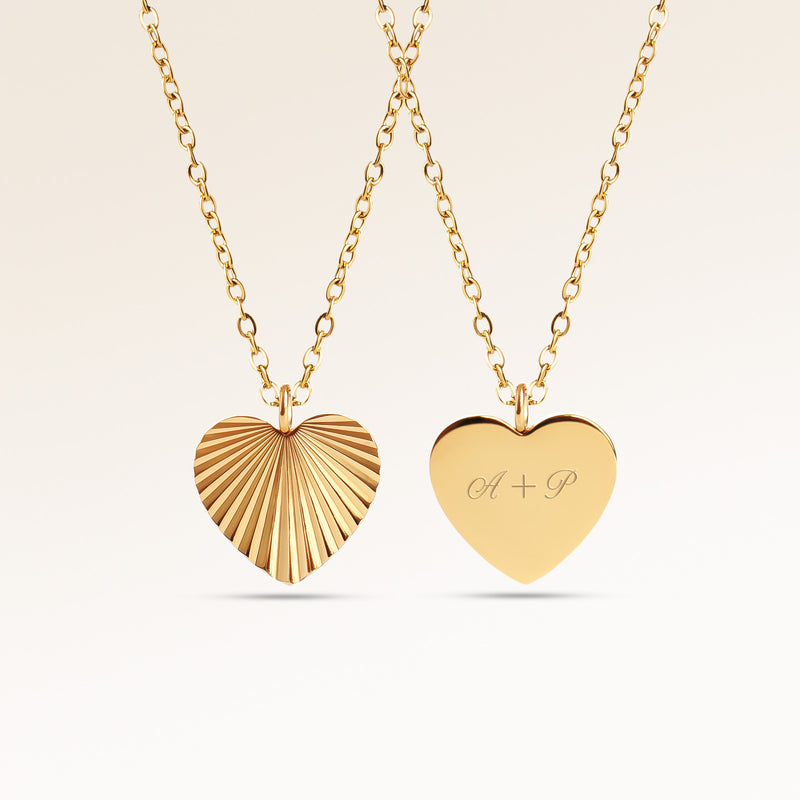 Heart-shaped gold necklace with ribbed sunburst pattern on front and personalized engraving of initials 'A + P' on back, from Mon Chou.