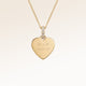 Close-up of minimalist heart-shaped heart pendant in gold with white zircons and space for personalized engraving on the front and back